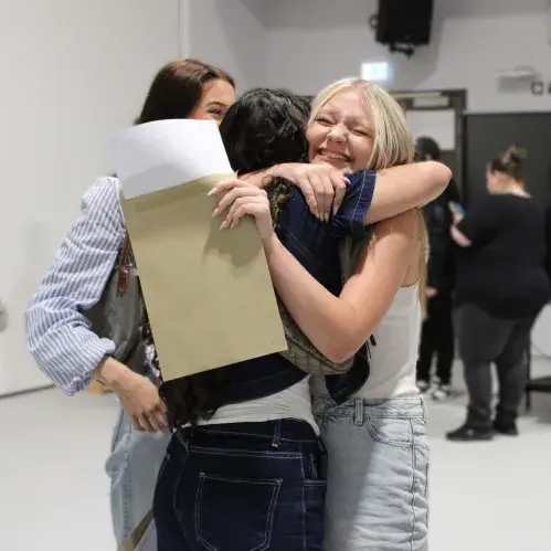 Student hugging friend celebrating GCSE results